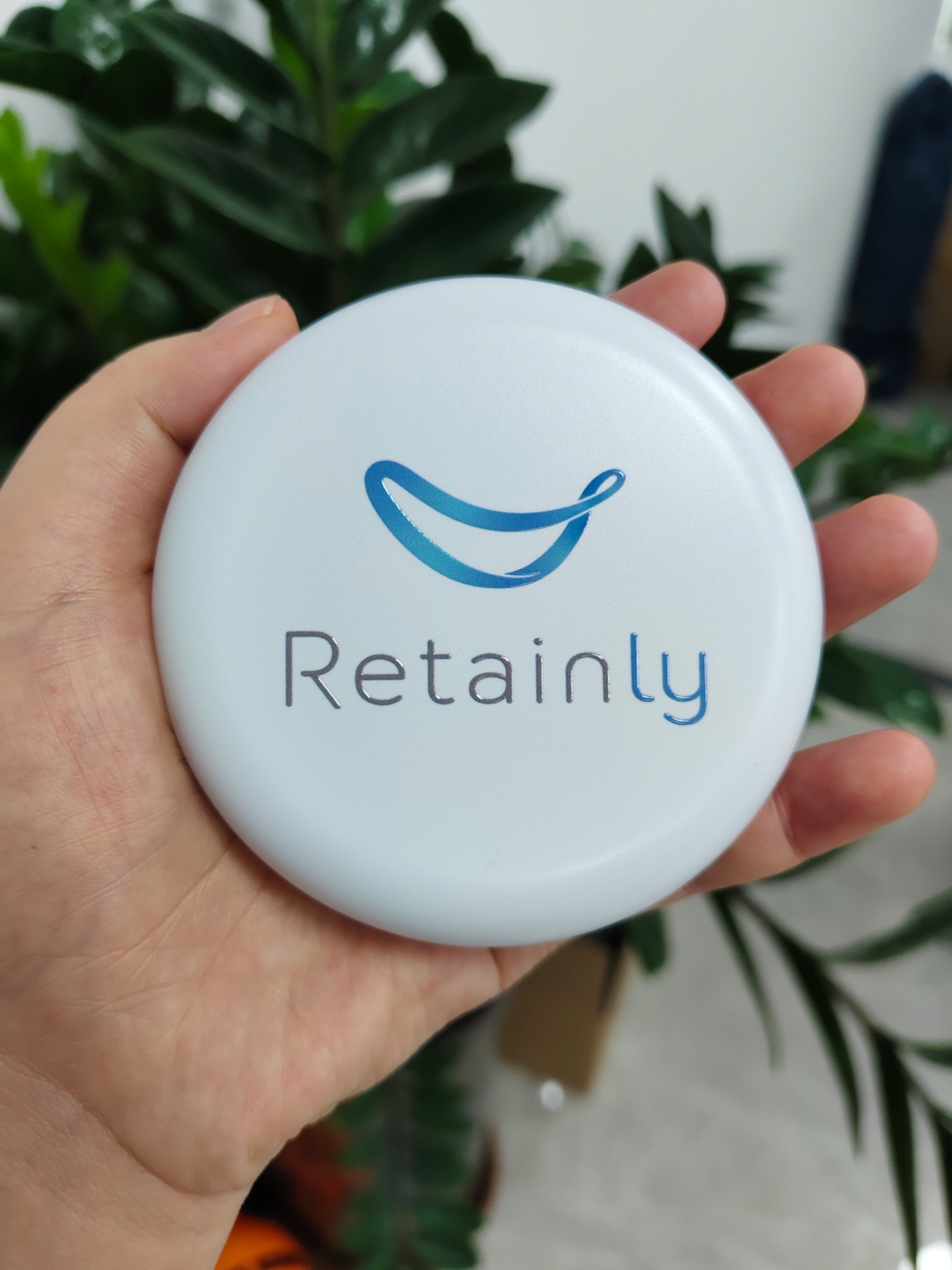 Round blue Retainly case in a hand